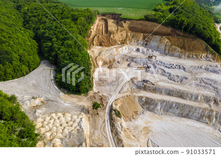 Open pit mining of construction sand stone materials with excavators and dump trucks. Open pit mining of construction sand stone materials with excavators and dump trucks. 91033571