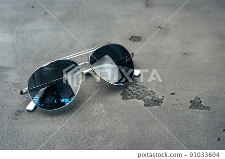 New dark aviator glasses on grey concrete background New dark aviator glasses on grey concrete background 91033604