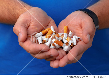 Male hands holding broken cigarettes close up Male hands holding broken cigarettes close up 91033606