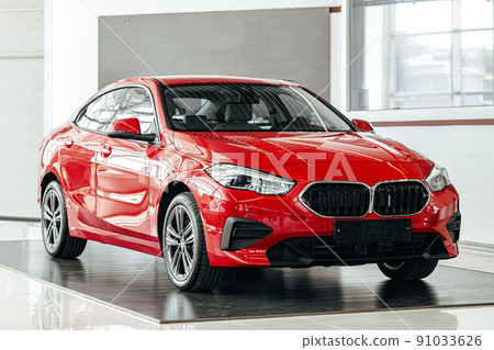 New red luxury car on a car presentation in showroom New red luxury car on a car presentation in showroom 91033626