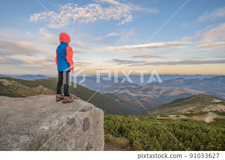 Young child boy hiker standing in mountains enjoying view of amazing mountain landscape. Young child boy hiker standing in mountains enjoying view of amazing mountain landscape. 91033627