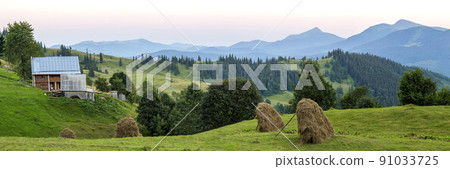 Village houses on hills with green meadows in summer day. House of shepherds in mountains in carpathian Village houses on hills with green meadows in summer day. House of shepherds in mountains in carpathian 91033725