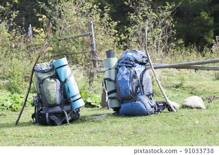Two touristic hikers backpacks standing in a mountain valley on sunny day Two touristic hikers backpacks standing in a mountain valley on sunny day 91033738
