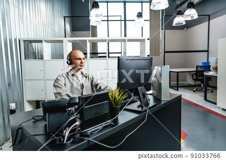 Young bald man working in a call center office Young bald man working in a call center office 91033766