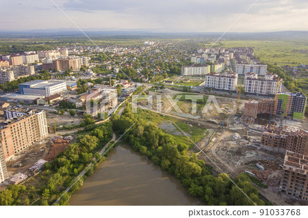 Top view of urban developing city landscape with tall apartment buildings and suburb houses. Drone aerial photography. 91033768