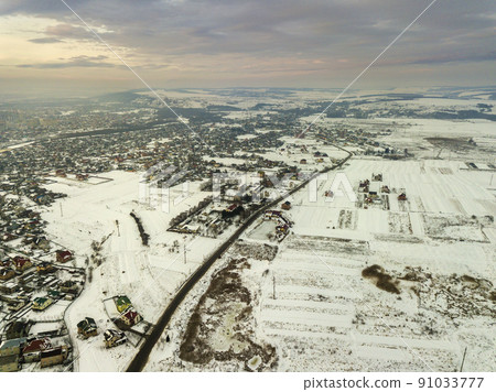 Top view of city suburbs or small town nice houses on winter morning on cloudy sky background. Aerial drone photography concept. Top view of city suburbs or small town nice houses on winter morning on cloudy sky background. Aerial drone photography concept. 91033777