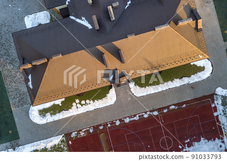 Top aerial view of building brown shingle tiled roof with complex configuration construction. Abstract background, geometrical pattern. 91033793
