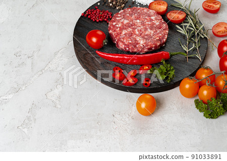 Fresh raw home-made cutlet with spices and tomatoes on the table Fresh raw home-made cutlet with spices and tomatoes on the table 91033891