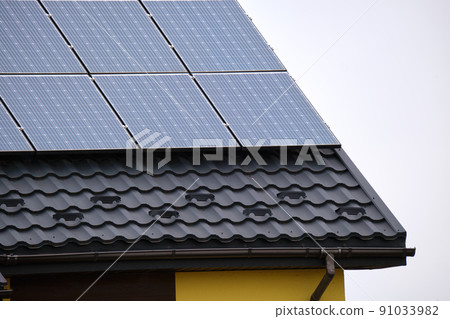 Residential house with rooftop covered with solar photovoltaic panels for producing of clean ecological electrical energy in suburban rural area. Concept of autonomous home Residential house with rooftop covered with solar photovoltaic panels for producing of clean ecological electrical energy in suburban rural area. Concept of autonomous home 91033982