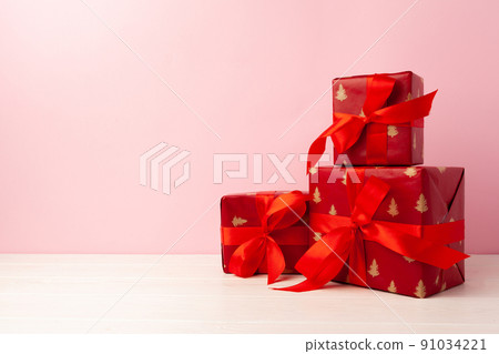 Several stacked Christmas gifts in festive wrapping 91034221