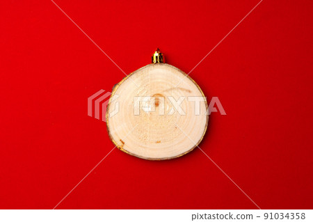 Christmas toy made of cross section of the tree on red Christmas toy made of cross section of the tree on red 91034358