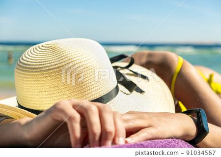 Close up of young woman hip and shoulder laying on beach chair at sea shore sunbathing. Close up of young woman hip and shoulder laying on beach chair at sea shore sunbathing. 91034567