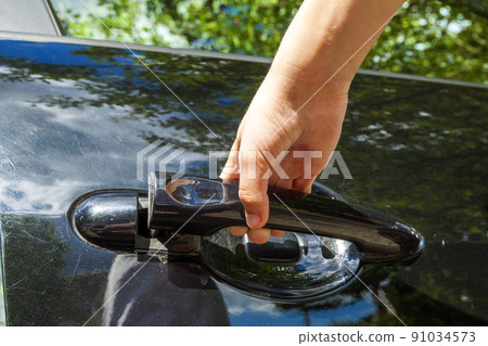 Close up of human child hand opening car door Close up of human child hand opening car door 91034573