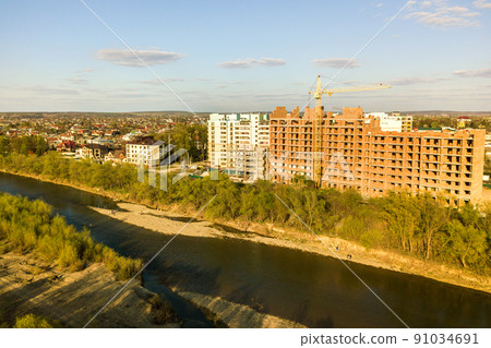 Aerial view of tall residential apartment buildings under construction and Bystrytsia river in Ivano-Frankivsk city, Ukraine. Aerial view of tall residential apartment buildings under construction and Bystrytsia river in Ivano-Frankivsk city, Ukraine. 91034691