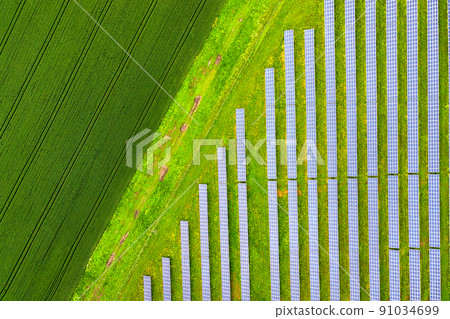 Aerial view of solar power plant on green field. Electric panels for producing clean ecologic energy. 91034699