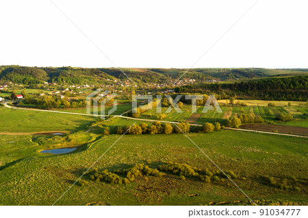 Aerial landscape view of green cultivated agricultural fields with growing crops on bright summer day 91034777