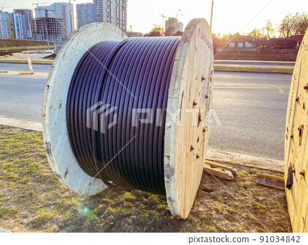 power line cable twisted into a ball. black long cable. laying a cable to supply the microdistrict with electricity power line cable twisted into a ball. black long cable. laying a cable to supply the microdistrict with electricity 91034842