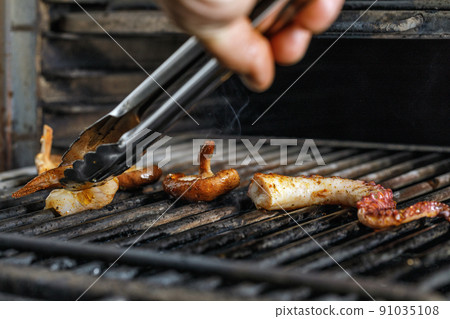 Process of grilling seafood on a barbecue grill over hot coal. Seafood recipes Process of grilling seafood on a barbecue grill over hot coal. Seafood recipes 91035108