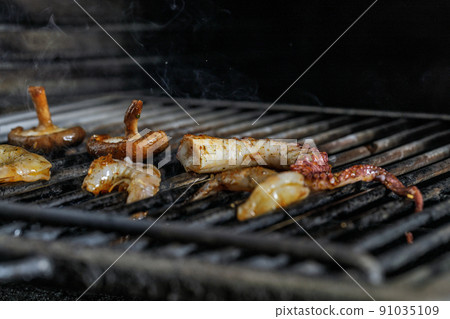 Process of grilling seafood on a barbecue grill over hot coal. Seafood recipes 91035109