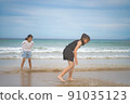 Children playing in the sea 91035123