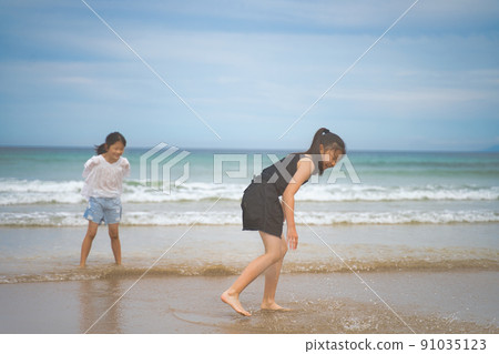 Children playing in the sea 91035123