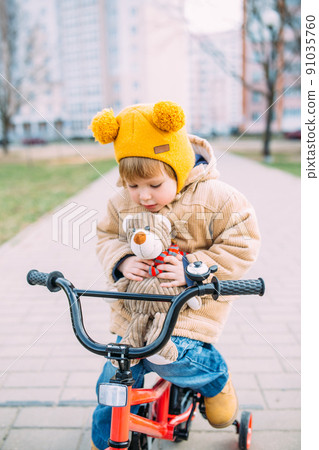 A small child learns to ride a bike for the first time in the city in spring 91035760