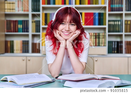 Portrait of beautiful female student looking at camera, sitting at desk in library Portrait of beautiful female student looking at camera, sitting at desk in library 91035815