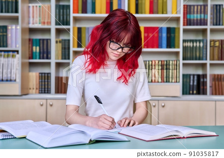 Teenage female student studying in library class Teenage female student studying in library class 91035817