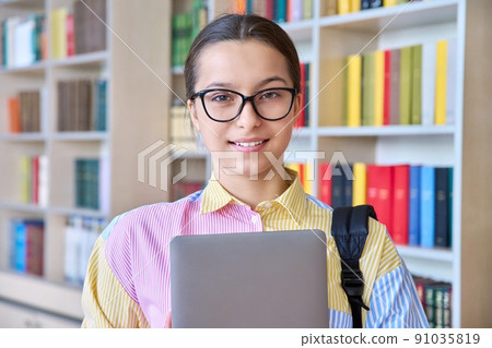 Portrait of high school student looking at camera in library 91035819