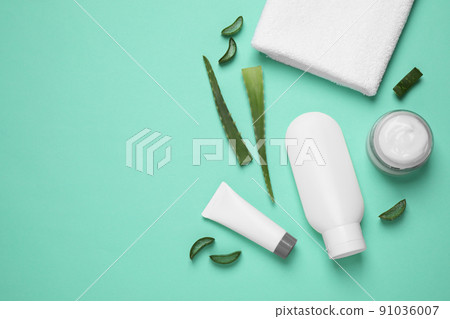 Flat lay composition with aloe vera and cosmetic products on turquoise background. Space for text 91036007