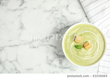 Delicious broccoli cream soup with croutons served on white marble table, top view. Space for text Delicious broccoli cream soup with croutons served on white marble table, top view. Space for text 91036064