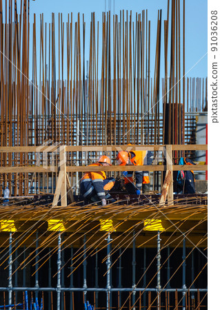 Anonymous men in uniforms working at construction site Anonymous men in uniforms working at construction site 91036208