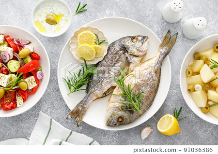 Dorada fish sea bream baked, fresh vegetable greek salad, boiled potatoes with garlic and olives 91036386