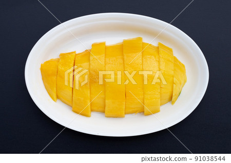 Yellow mango slices on dark background. Yellow mango slices on dark background. 91038544