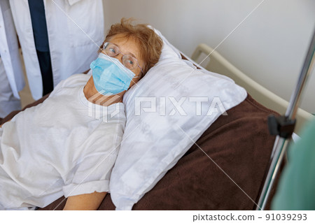 Senior female patient in mask in the ward of modern medical clinic during Covid-19 Pandemic 91039293