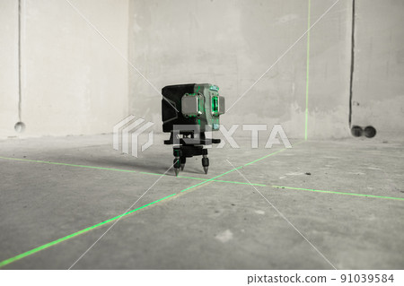 Laser level, construction, finishing work in the room. Laser building level with green beams on the wall bare cement of the house Laser level, construction, finishing work in the room. Laser building level with green beams on the wall bare cement of the house 91039584