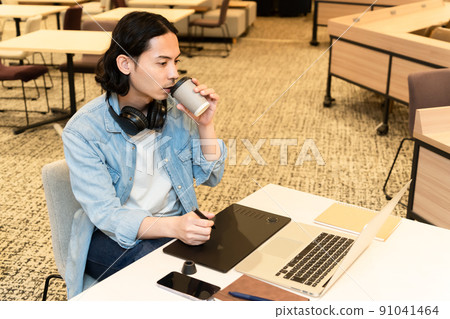 一個戴著耳機在平板電腦上工作的男人 一個戴著耳機在平板電腦上工作的男人 91041464