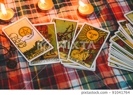 Tarot reading with tarot card background and candlelight on the table for Astrology Occult Magic Spiritual Horoscopes and Palm reading fortune teller tarot reader 91041764