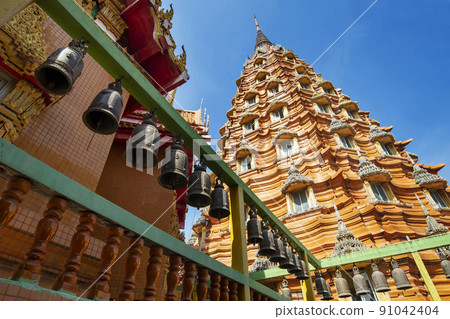 Rows of bells leading in line to beautiful large pagoda at buddhist temple 91042404
