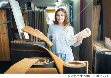 Woman consumer choosing carpet in hardware store Woman consumer choosing carpet in hardware store 91044271