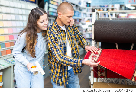 Young smiling woman and man choosing flooring samples Young smiling woman and man choosing flooring samples 91044276