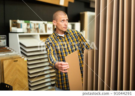 Man choosing flooring in store Man choosing flooring in store 91044291