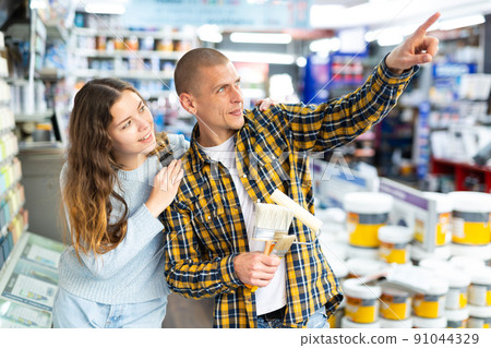 Couple shopping in building store pointing to something 91044329