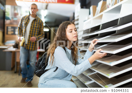 Woman chooses laminate flooring in store Woman chooses laminate flooring in store 91044331