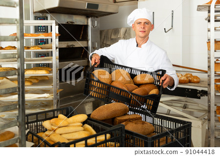 Portrait of baker with fresh bread at bakery Portrait of baker with fresh bread at bakery 91044418