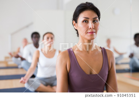 Young woman practicing meditation at yoga class Young woman practicing meditation at yoga class 91045351