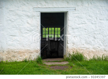 View through open doorway in colonial American stone springhouse 91045397