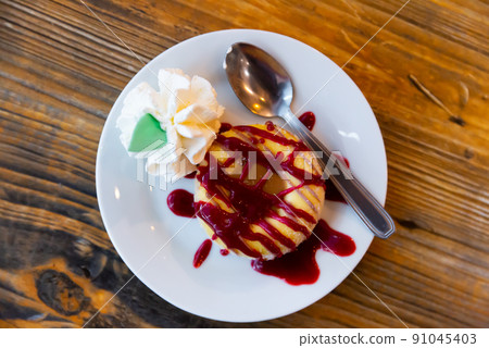 Cookie with ice-cream and berry jam served on table Cookie with ice-cream and berry jam served on table 91045403