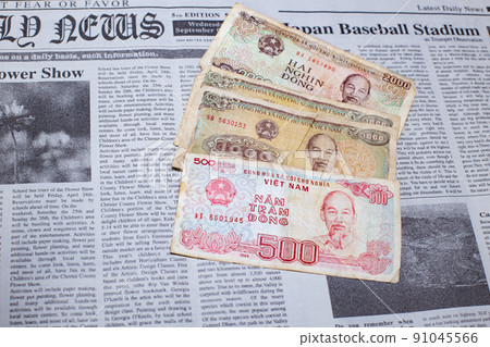 Vietnamese dong placed on an English newspaper 91045566