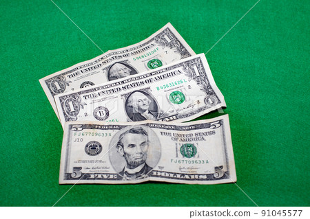 US $ 1 and $ 5 bills on a green background 91045577